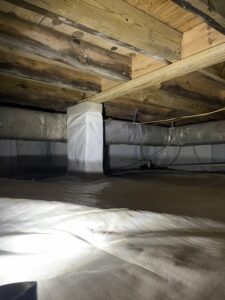 Crawl space with wooden beams, wrapped pipes, and a plastic-covered floor.